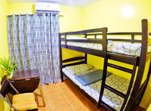 Habitación con 2 literas, mesa y escritorio. en ARC 2219 Home Rentals 2BR en Cebú