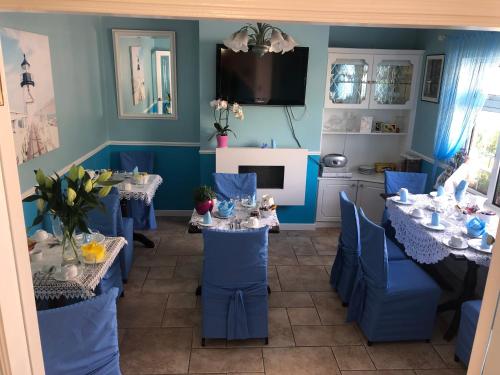 un comedor con paredes azules, sillas y mesas azules en Kinsale B&B en Scilly