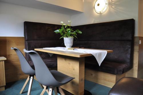 a table with two chairs and a potted plant on it at Active Apart Central in Ried im Oberinntal