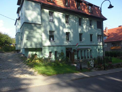 een groot wit gebouw aan de straatkant bij Bezowy pokój in Jedlina-Zdrój