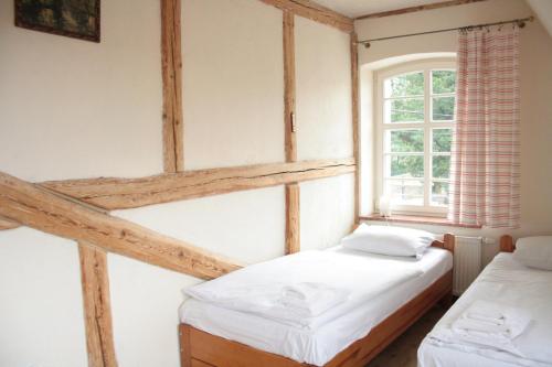 two twin beds in a room with a window at Karczma Bełty in Glinno