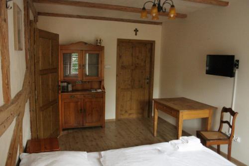 a bedroom with a bed and a table and a desk at Karczma Bełty in Glinno