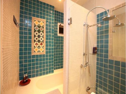 a green tiled bathroom with a shower and a tub at At Niman conceptual Home chiangmai in Chiang Mai