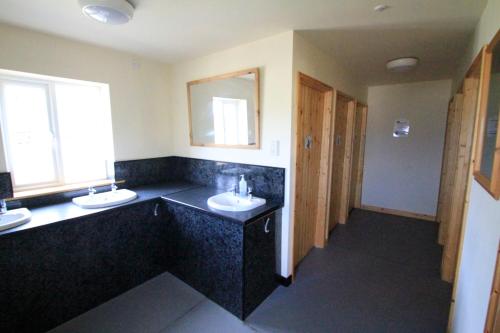 Baño con 2 lavabos y espejo en Woodbatch Camping & Glamping en Bishops Castle