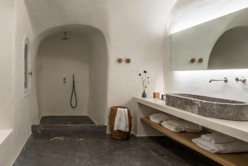 a bathroom with a sink and a bath tub at Chelidonia Luxury Suites in Oia