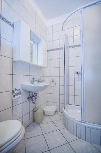 a bathroom with a toilet and a sink and a shower at Apartments Pušić in Omiš