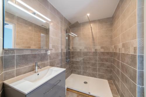 a bathroom with a white sink and a shower at Hôtel Au Coq Dort Spa in Châtillon-sur-Chalaronne