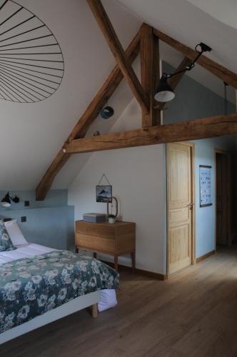 a bedroom with a bed and a wooden ceiling at Le champ Bagnolet in Voussac