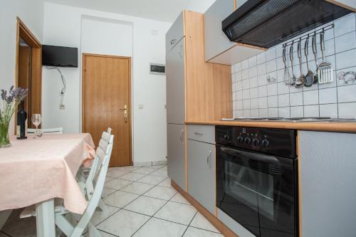 a kitchen with a table and a stove top oven at Apartments Pušić in Omiš