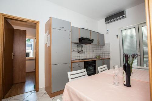 a kitchen with a table with a bottle of wine at Apartments Pušić in Omiš
