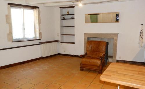 ein Wohnzimmer mit einem Stuhl und einem Kamin in der Unterkunft l'atelier du relieur in Montmorillon