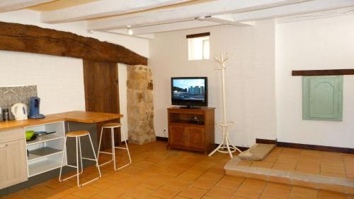 a living room with a television and a counter at l'atelier du relieur in Montmorillon