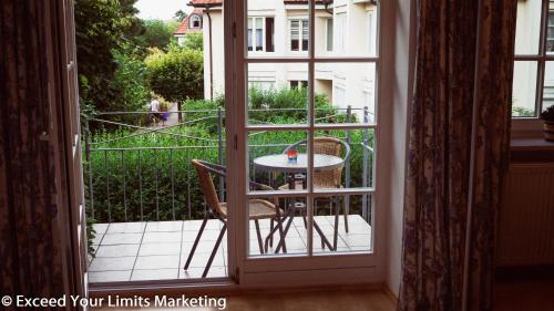 an open door with a table and chairs on a balcony at Hotel Zwei Länder in Apolda