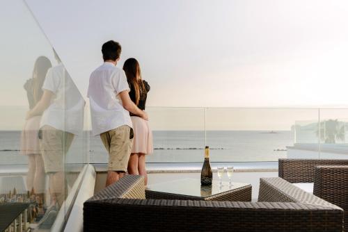 a couple standing on a balcony looking out at the ocean at Residence Picalè in Alghero