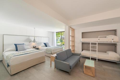 a bedroom with two beds and a bunk bed at Catalonia Punta Cana - All Inclusive in Punta Cana
