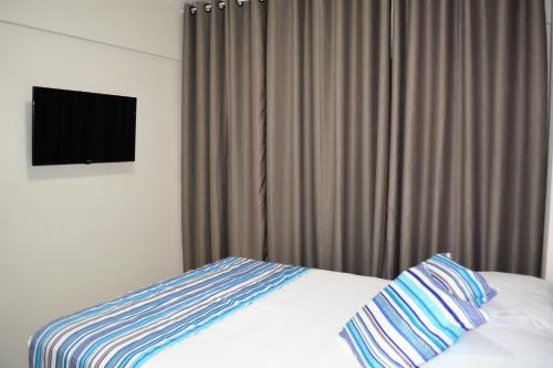 a bedroom with a bed with a television in it at Sun Paradise - JTR in Maceió