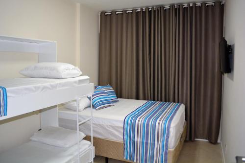 a small room with two beds and a curtain at Sun Paradise - JTR in Maceió