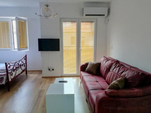 ein Wohnzimmer mit einem roten Sofa und einem Couchtisch in der Unterkunft Apartment Maris in Ohrid