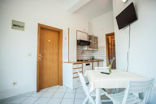 a kitchen with a table and chairs and a television at Apartments Pušić in Omiš