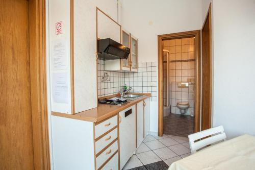 a small kitchen with a sink and a toilet at Apartments Pušić in Omiš