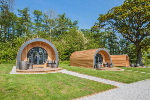 a small wooden building in a park with trees at High Oaks Grange - Glamping in Pickering