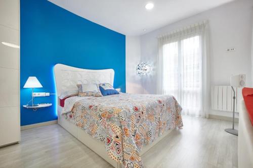 a blue bedroom with a bed and a blue wall at El encanto de Avilés, apartamento-loft in Avilés