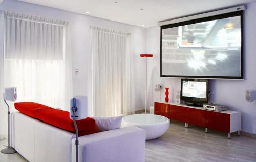 a living room with a tv and a large screen at El encanto de Avilés, apartamento-loft in Avilés
