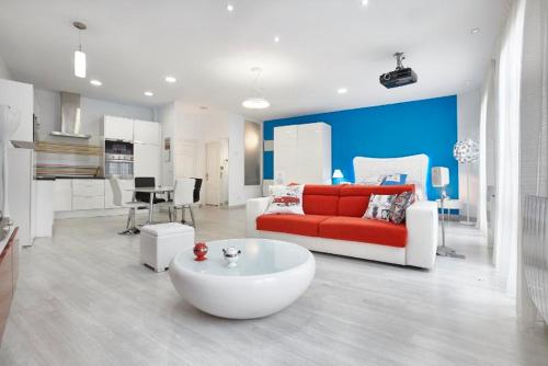 a living room with a red couch and a white table at El encanto de Avilés, apartamento-loft in Avilés
