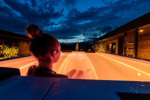 a woman sitting on a ledge looking at a street at B&B Boutique Apartment Oberwiesen in Brunico