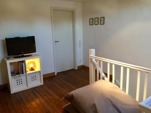 a room with a bed and a tv on a stand at La villa des Savoyards in Vielsalm