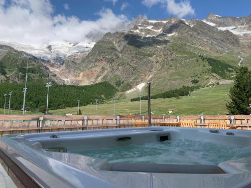 a hot tub with a view of a mountain at Palace Luxury Wellness Apartment and Boutique Hotel Ski-in-out in Saas-Fee