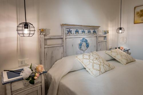 una camera con un letto bianco con due cuscini di Le Perle del Golfo a Castellammare del Golfo