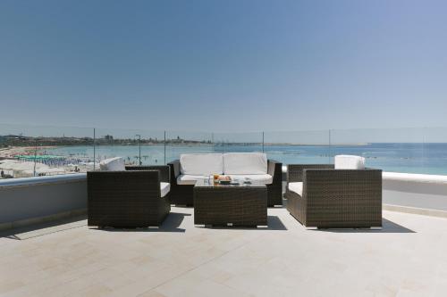 a patio with three chairs and a table on a roof at Residence Picalè in Alghero