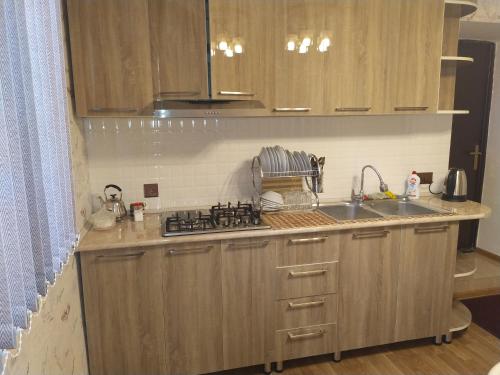 a kitchen with a sink and a stove top oven at VM Hostel in Ganja