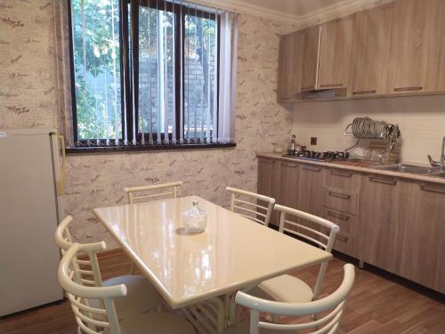 a kitchen with a table and chairs and a refrigerator at VM Hostel in Ganja