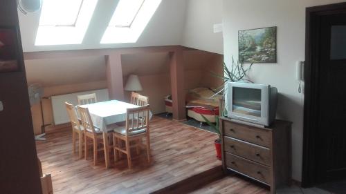 a kitchen and dining room with a table and a tv at Pod Sarenką in Szczawnica