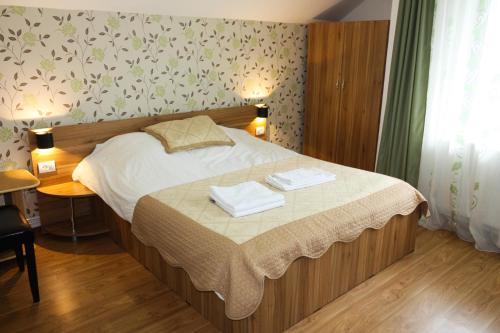 a bedroom with a bed with two towels on it at Perla Munților in Ranca