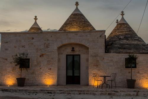 a building with a table and chairs in front of it at Trulli Nannì in Locorotondo
