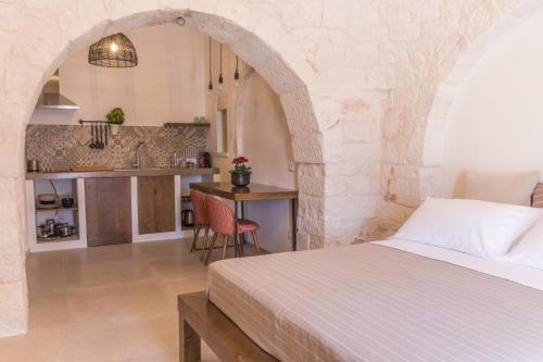 a bedroom with a bed and a kitchen in a room at Trulli Nannì in Locorotondo