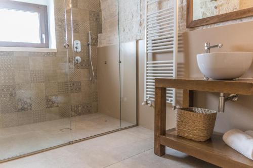 a bathroom with a sink and a glass shower at Trulli Nannì in Locorotondo