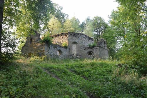 an old stone building in the middle of a field at U Jędrusia in Polańczyk