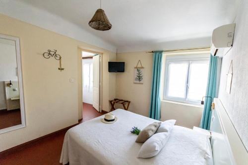 a bedroom with a white bed and a window at Hotel Le Flore in Fréjus