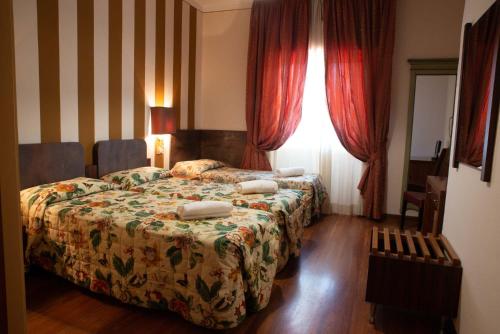 Habitación de hotel con 2 camas y ventana en Vivo Hotel, en Pieve a Nievole