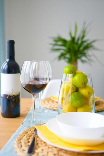a table with a glass of wine and a plate of fruit at Elizabeth Garden Apartment in Kecskemét