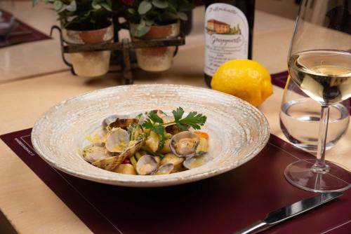 a bowl of seafood on a table with a glass of wine at Vivo Hotel in Pieve a Nievole