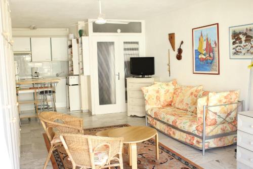 una sala de estar con un sofá y una mesa en STUDIO STANDING BORD DE MER ET VUE, en Antibes