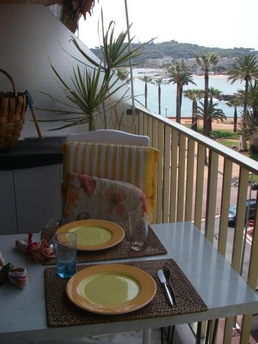 une table avec deux assiettes de nourriture sur un balcon dans l'établissement STUDIO STANDING BORD DE MER ET VUE, à Antibes