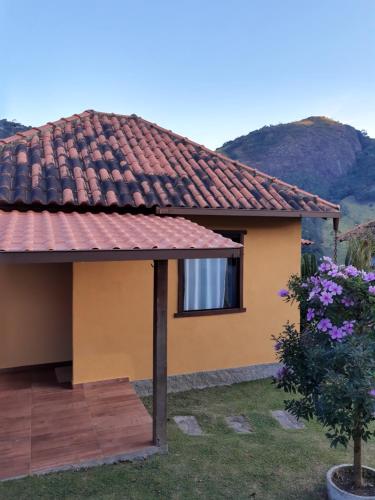 a yellow house with a red tile roof at Chalés da Serra in São Pedro da Serra