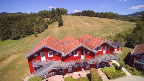 een luchtzicht op een groot rood huis op een heuvel bij Hotel Bayerischer Wald in Neukirchen