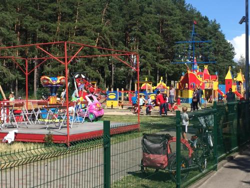 an amusement park with a roller coaster and a playground at Red Tower Apartments in Palanga